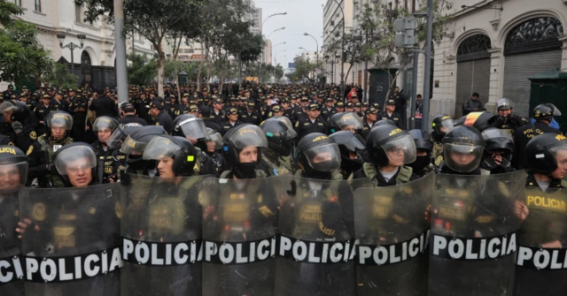 Policiais em linha reta com escudos