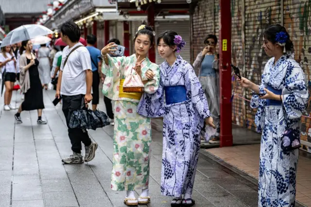 Três mulheres japonesassite blaze crashquimono na rua.