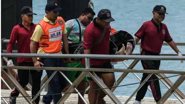 เจ้าหน้าที่นำร่างของผู้เสียชีวิตขึ้นมาจากน้ำ