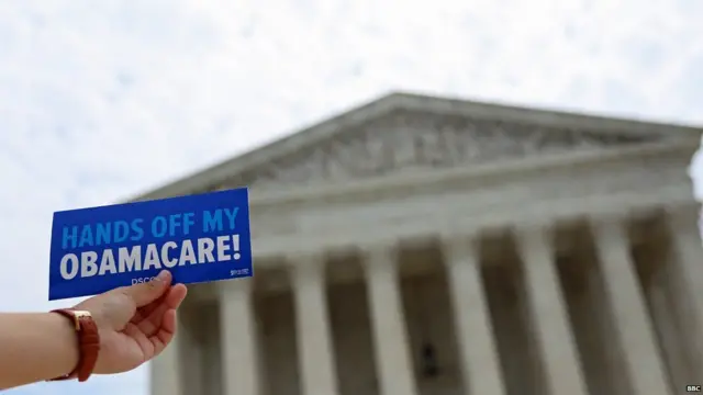 Mano sostiene cartel a favor del "Obamacare".