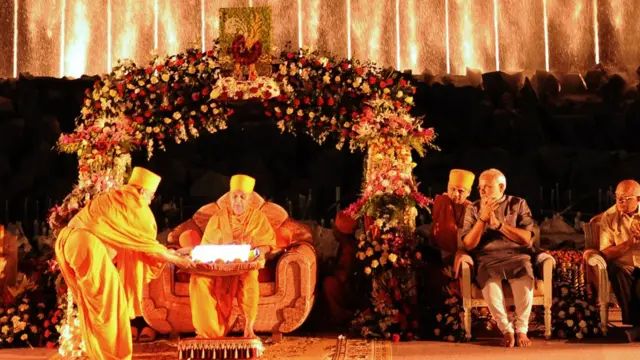 BAPSના તત્કાલીન વડા પ્રમુખ સ્વામી સાથે ગાંધીનગરના અક્ષરધામ મંદિરમાં યોજાયેલા એક કાર્યક્રમમાં નરેન્દ્ર મોદી, એ સમયે મોદી ગુજરાતના મુખ્યમંત્રી હતા