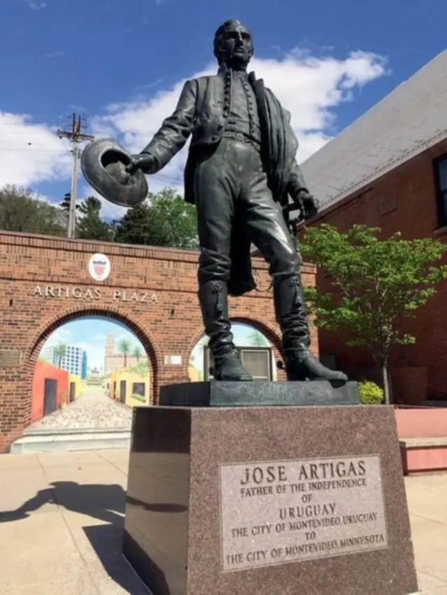 La estatua de Artigas en la plaza Artigas delante del mural con otro Artigas.