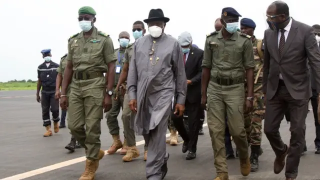 Former Nigerian President Goodluck Jonathan (2L) walks at the International Airport in Bamako upon his arrival on August 22, 2020 next to by Malick Diaw (L), the Vice President of the CNSP (National Committee for the Salvation of the People). - A delegation of West African leaders headed by former Nigerian president Goodluck Jonathan arrived in the Malian capital Bamako on August 22 on a mission to restore order after a military coup.