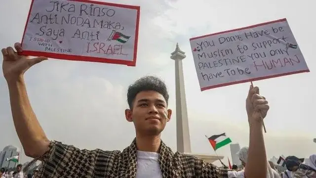 Warga membawa poster saat aksi akbar Aliansi Rakyat Indonesia Bela Palestina di Lapangan Silang Monas, Jakarta, Minggu (5/11/2023).