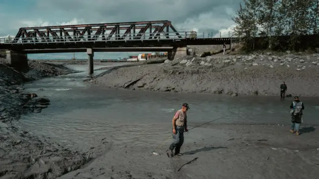 Чоловік тримає вудку біля річки