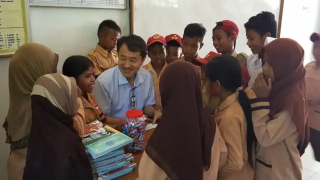 Jung Deuk Young dikelilingi oleh murid-murid yang dia ajar aksara Hangeul.