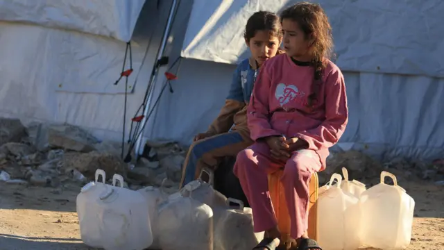 يجلس أطفال فلسطينيون نازحون في مخيم خيام، بعد أن أعلنت الولايات المتحدة يوم الأربعاء إطلاق المرحلة الثانية من خطتها لإنهاء حرب غزة، في مدينة غزة، 15 يناير/كانون الثاني 2026.