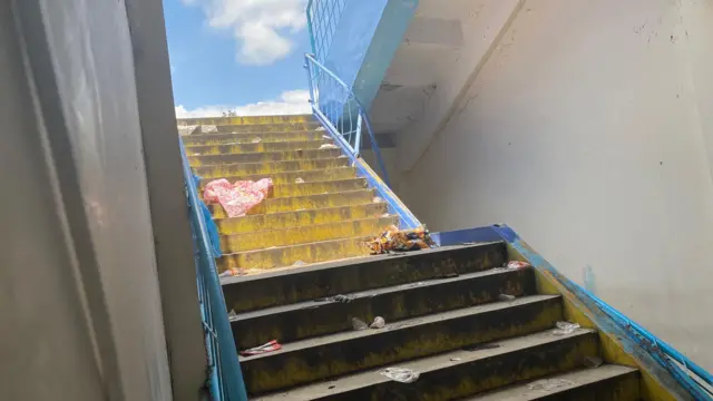 Di lantai datar tangga menuju pintu keluar stadion, para penonton berjatuhan dan saling menimpa.