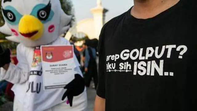 Maskot pemilu membawa poster saat sosialisasi pemilu di kawasan Nol Kilometer Yogyakarta, Jumat (22/12/2023).