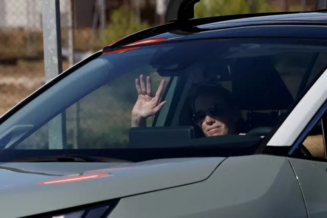 Carolina González, hija de Edmundo González, saluda desde el interior de un auto en el aeropuerto militar de Torrejón de Ardoz, Madrid.