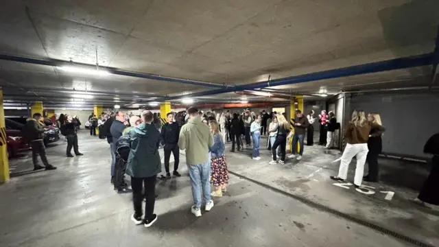 Подземная парковка, на которой столпилось множество людей