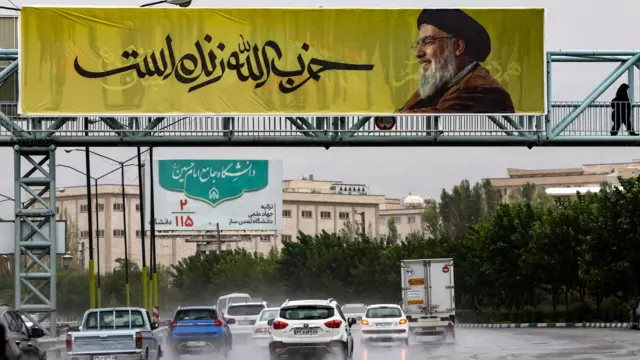 तेहरान में हिज़्बुल्लाह के समर्थन में लगा पोस्टर