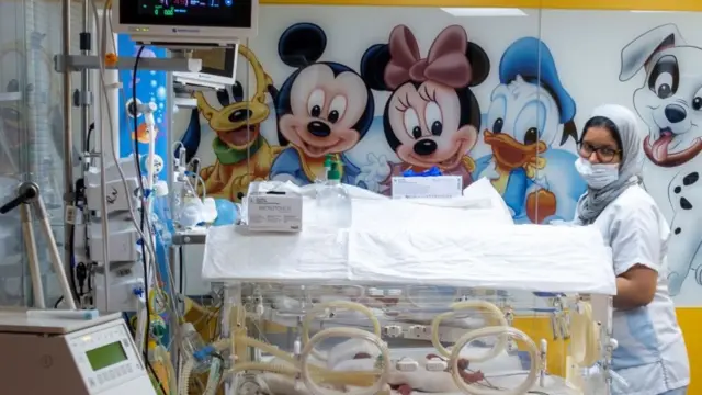 மருத்துவமனையில் ஒரே பிரசவத்தில் பிறந்த ஒன்பது குழந்தைகளில் ஒன்றைப் பராமரிக்கும் செவிலியர்