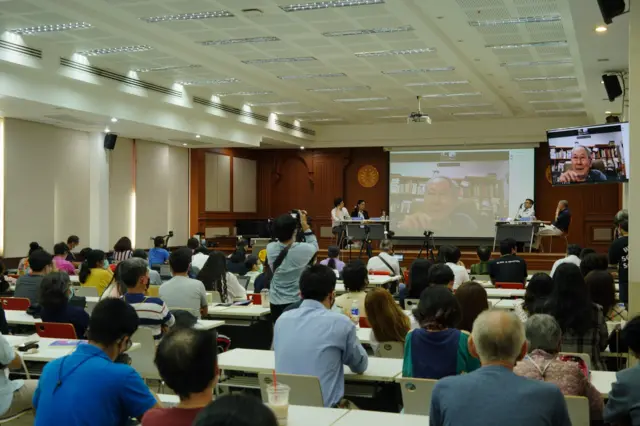 คนฟังในห้องประชุม บนจอเป็นภาพ นิธิ เอียวศรีวงศ์