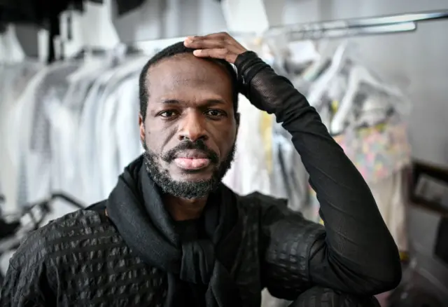 Cameroonian fashion designer Imane Ayissi supervises a model during the shooting of the video presentation of his Haute Couture Fall Winter 2021-2022 collection, in Paris, on July 3, 2021.