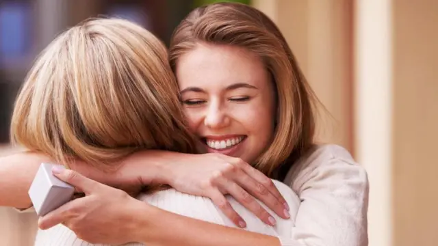 امرأة تعانق صديقتها بعد تبادل الهدايا