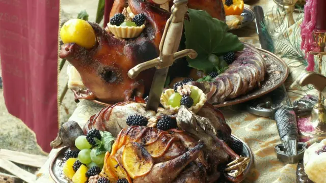 Жареный поросенок на заставленном блюдами столе.