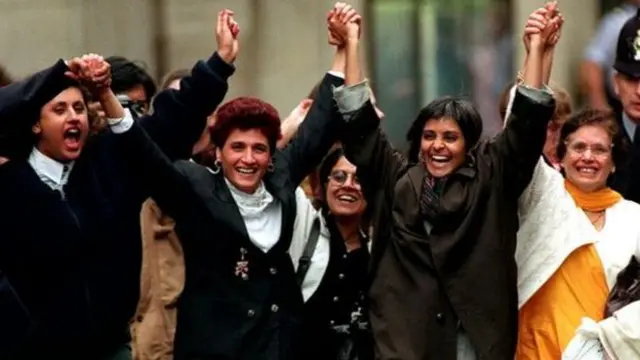 Kiranjit Ahluwalia (second from left) dey hold hands wit Pragna Patel (second from right) as she dey waka free from prison