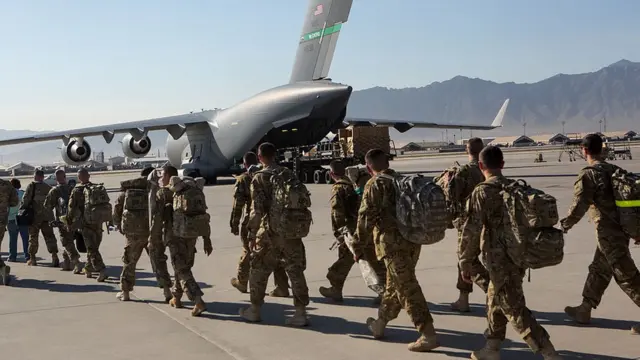 Soldados estadounidenses marchan hacia un avión de transporte en la base aérea de Bagram, 11 de mayo de 2013
