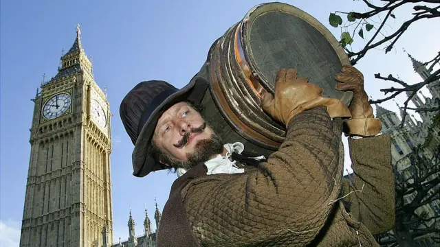 Actor interpretando a Guy Fawkes cargando pólvora