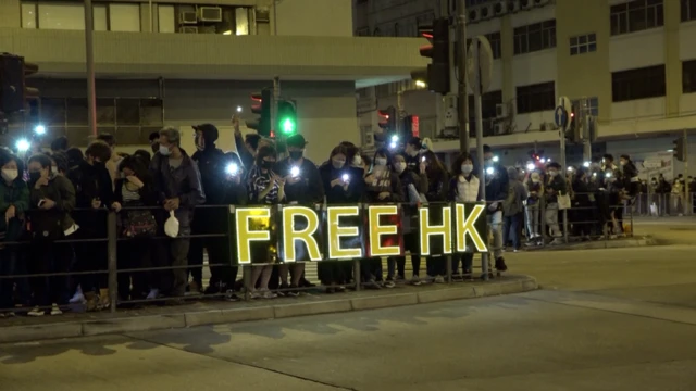 Protesters showing a neon sign that reads "Free Hong Kong"