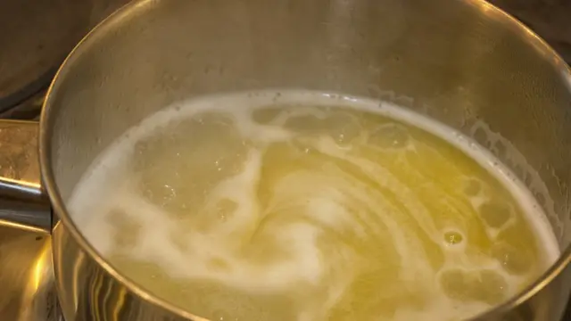 Масло и вода в кастрюле.