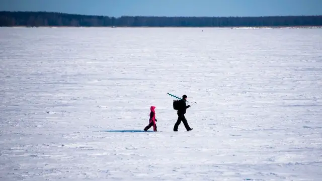 Чоловік із сином іде по снігу в Фінляндії