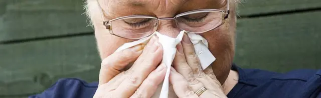 Woman blowing her nose
