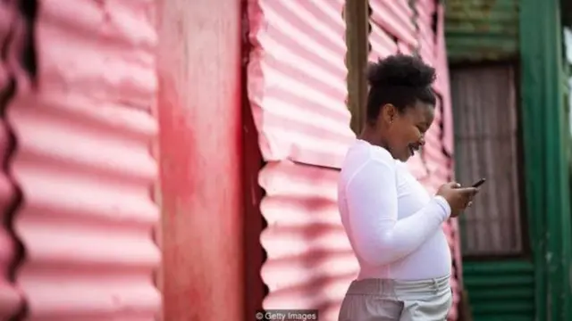 मोबाइल इस्तेमाल करती महिला