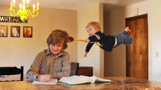 Wil en el aire tocando la cabeza de su hermano con una cuchara de madera