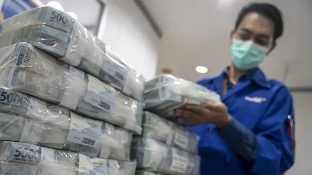 Petugas menyusun tumpukan uang di Cash Pooling Bank Mandiri, Jakarta, Kamis (23/06)