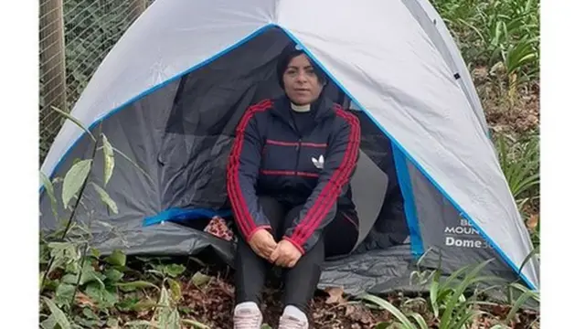 Reverend Major seated inside her tarpaulin tent outside the Achbishop's residence in Cape Town