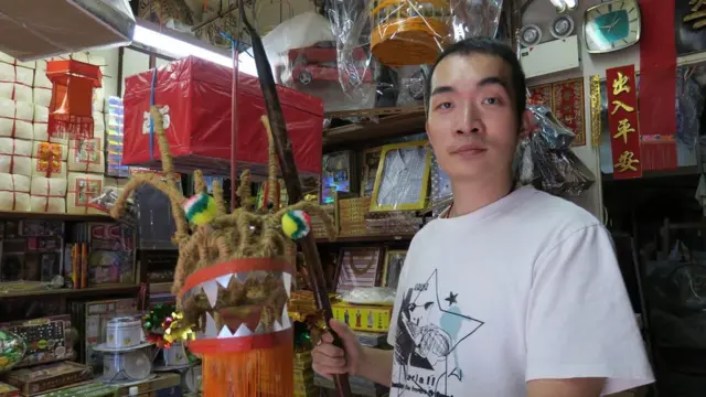 欧阳秉志拿着一件试作龙头作品（BBC中文网图片）