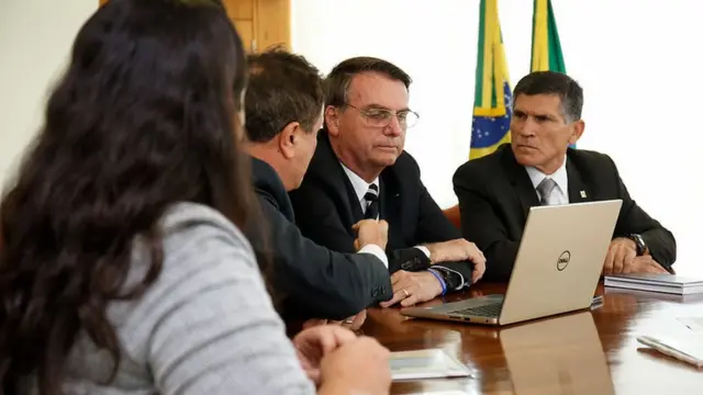 Bolsonaro e Santos Cruz sentados à mesa diantesites de apostas confiaveis loteriaslaptopsites de apostas confiaveis loteriasreunião