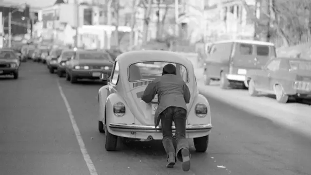 তেলের অভাবে মাঝপথে বন্ধ হয়ে যাওয়া গাড়ি ঠেলে নিয়ে চলেছেন একজন: বোস্টন ১৯৭৩