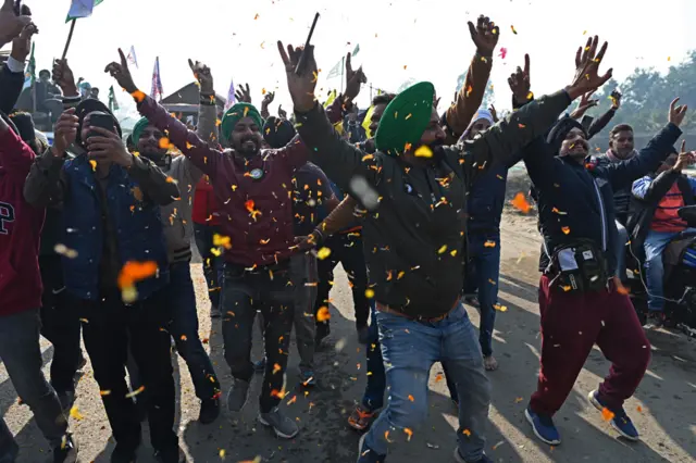 दिल्ली हरियाणा सीमामा विरोध प्रदर्शन स्थल छोड्दै गर्दा हर्ष प्रकट गर्दै भारतीय किसानहरू। ११ डिसेम्बर