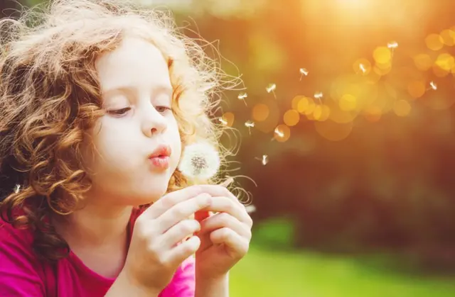 Niña con flor diente de león.