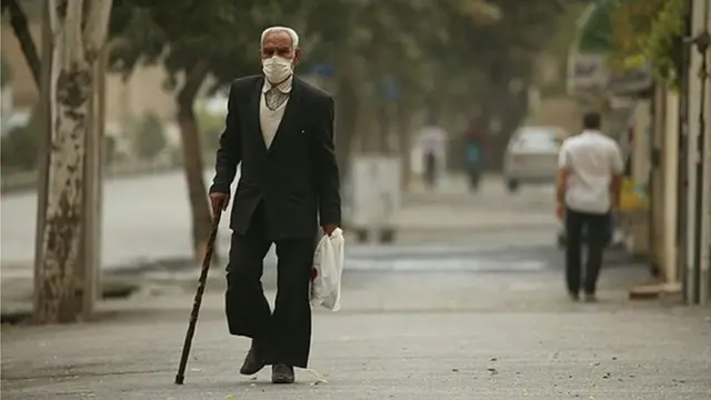 مرد مسنی با ماسک در هوای آلوده شهر اراک