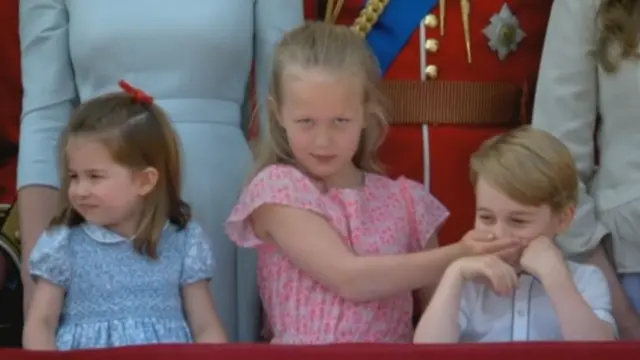 Savannah, the Queen's great-granddaughter and daughter of Peter and Autumn Philips, covers Prince George's mouth