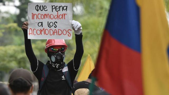 "Que pena incomodar a los acomodados", dice el cartel que sostiene un manifestante en las protestas que irrumpieron en mayo en Colombia.