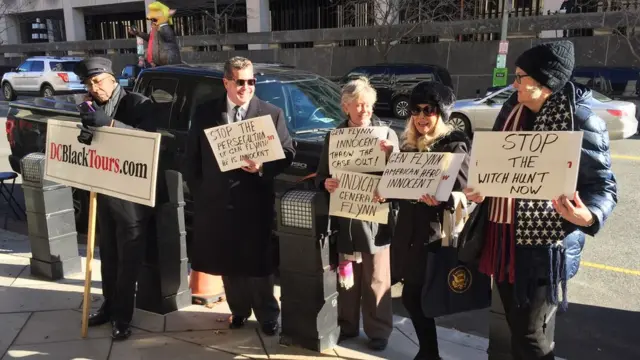 У здания окружного суда собрались несколько человек с плакатами в поддержку Флинна