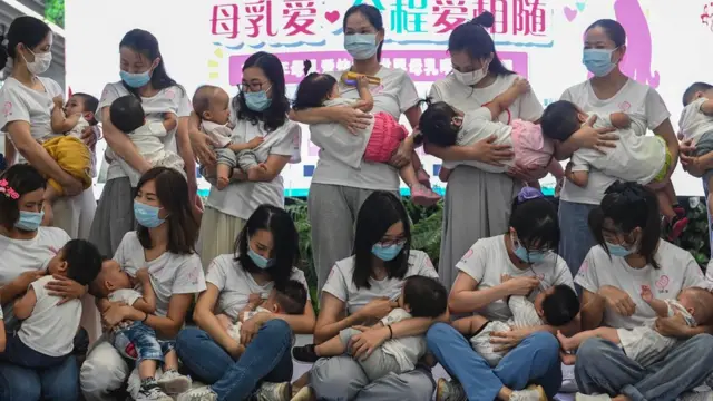 Twenty mothers breastfeed their children during a flash mob event to raise public awareness of breastfeeding at a subway station on 31 July 2020 in Guangzhou, Guangdong Province of China.