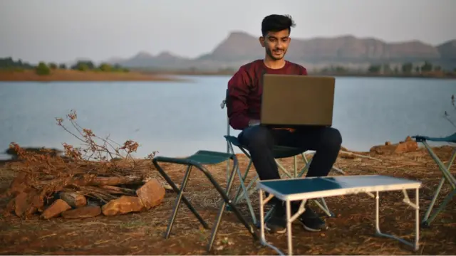 Homem trabalha com laptop