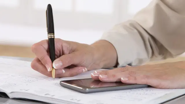 жінка пише у блокноті