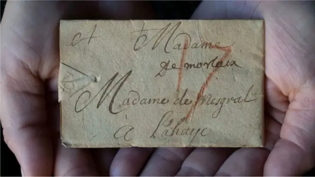 Un exemple d'une lettre fermée, avec un crayon rouge indiquant le coût de l'affranchissement.