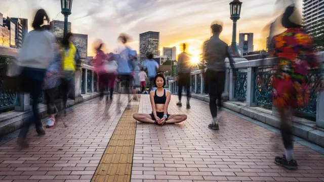 Mujer meditando en la calle.