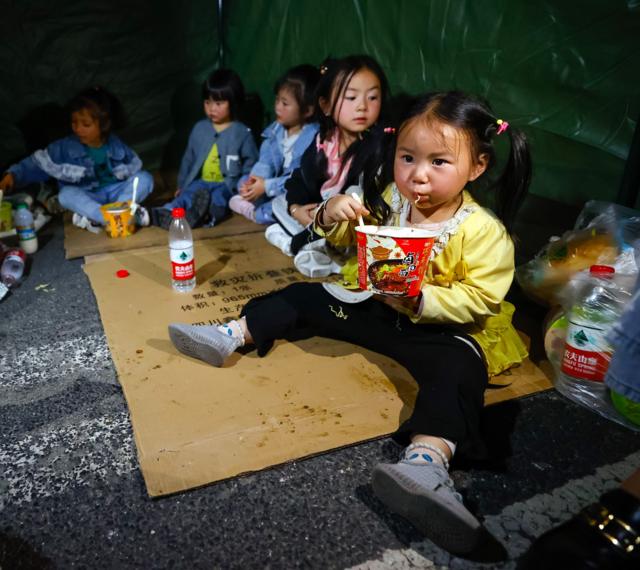 9月5日晚，在四川甘孜州瀘定縣磨西鎮的受災群眾臨時安置點，幾個家庭的孩子們在一個帳篷裏吃飯、休息。