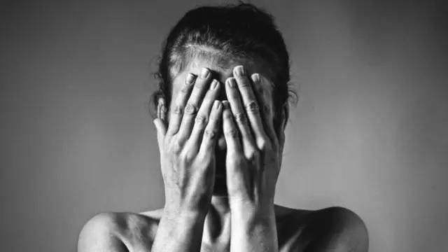 ముఖానికి చేతులు అడ్డం పెట్టుకున్న మహిళ