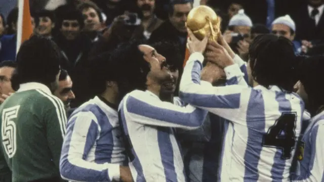 Jogadores sorrindo e erguendo taça