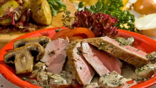 Мясо с грибами на тарелке